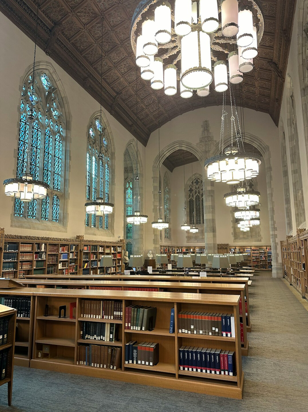 Quiet historic library with tall wooden shelves of archival books